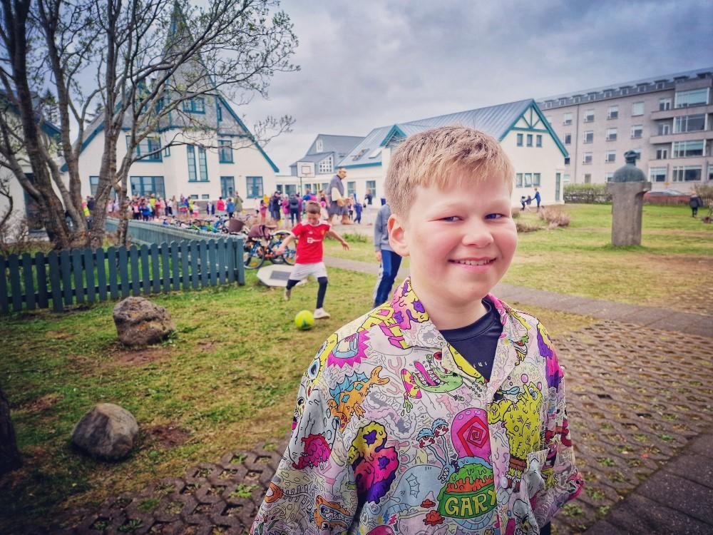 Guðjón Ingi Skúlason, í 6. bekk Landakotsskóla. Stendur fyrir utan skólann, í litríkri skyrtu. Krakkar á bakvið hann. Guðjón var annar tveggja sem afhentu borgarstjóra undirskriftalista því börnin vildu nýjan fótboltavöll við skólann.