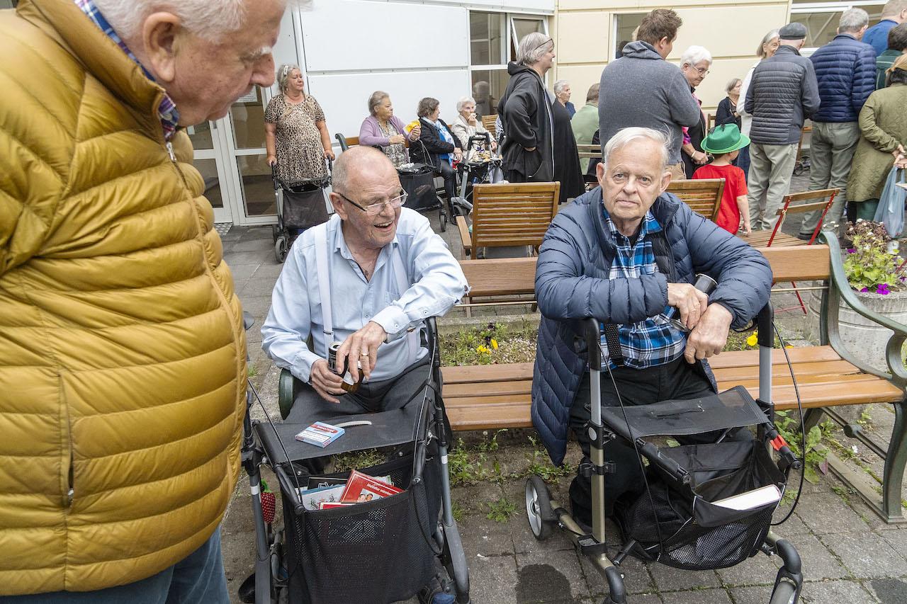 Tveir menn sitja á bekk og ræða málin. 