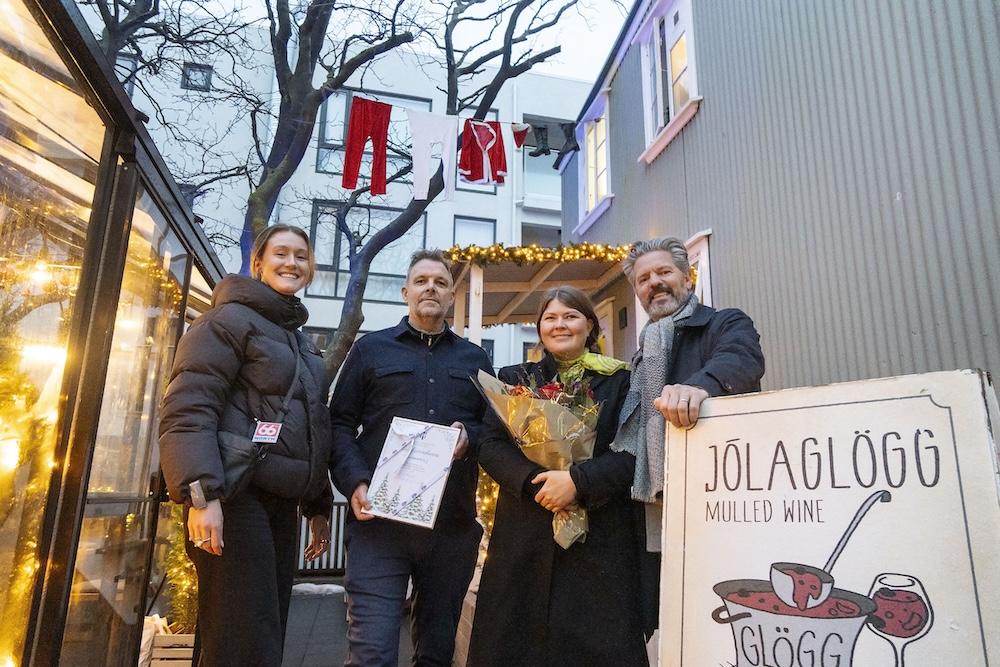 Fólk við jólaskreytt hús.