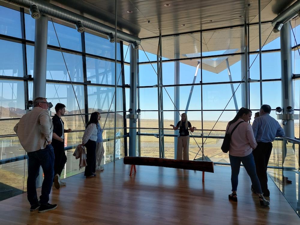 People by a large window in a house.