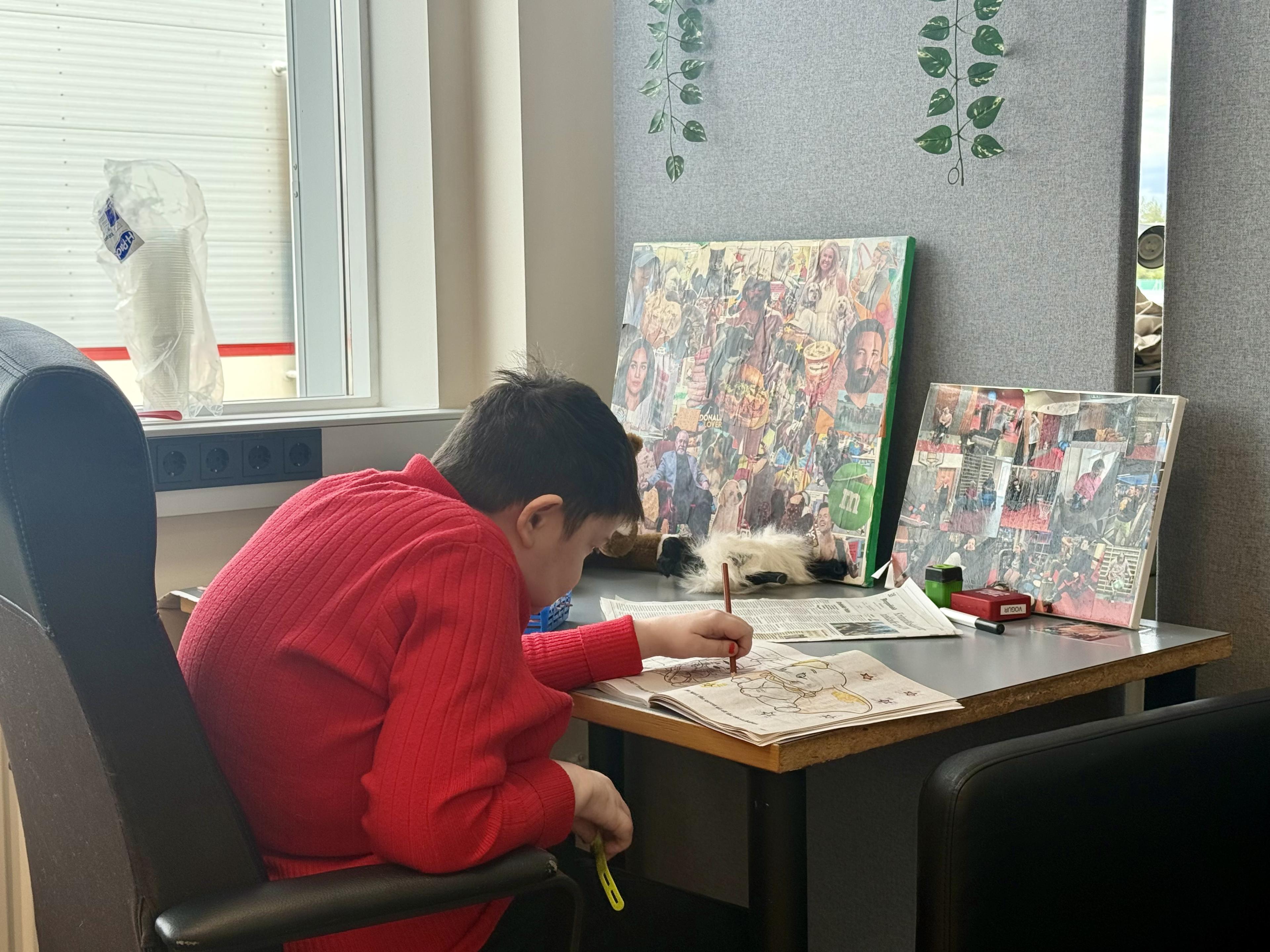 One of the work and activity center participants draws in a book. 