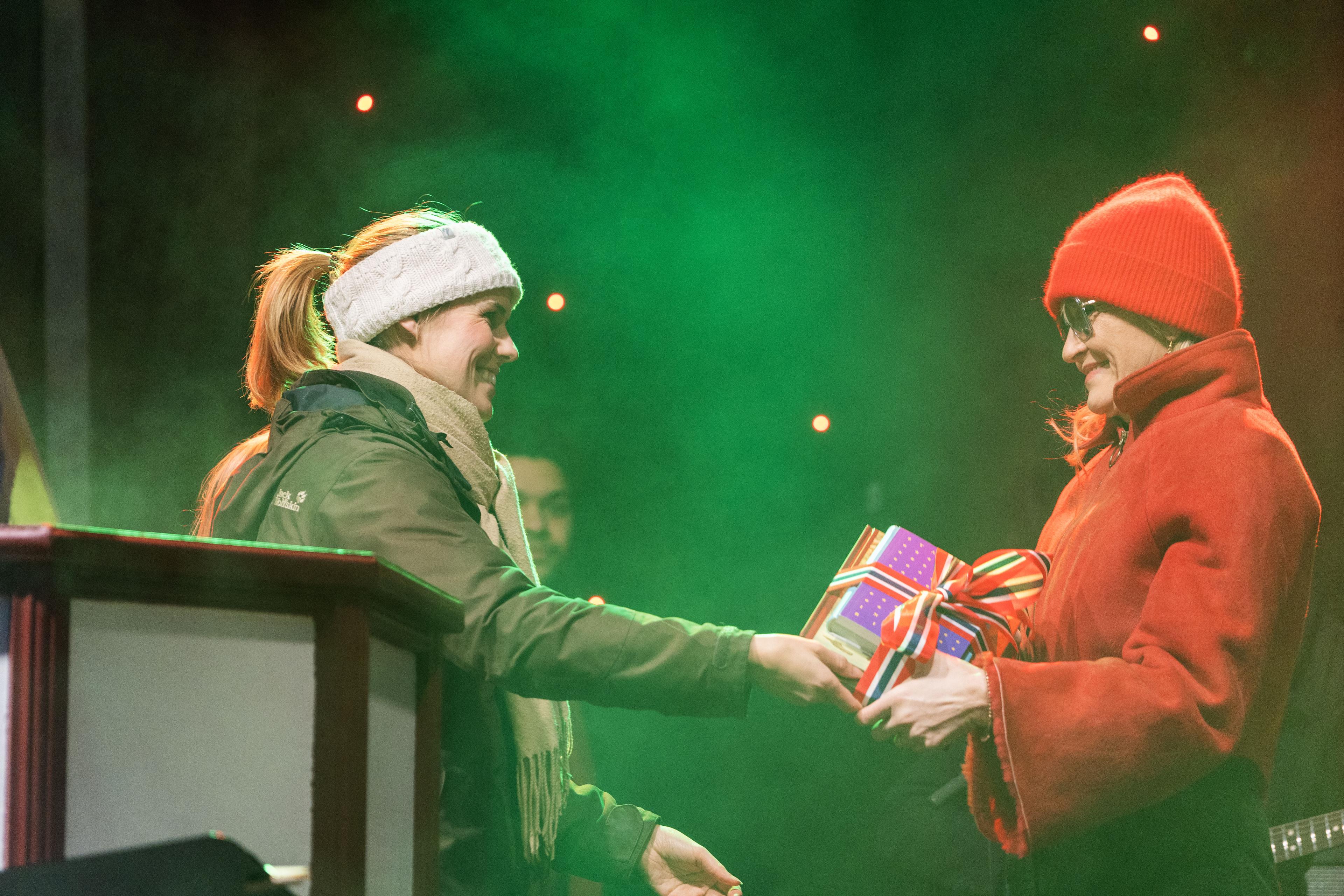 Woman hands package to another woman 