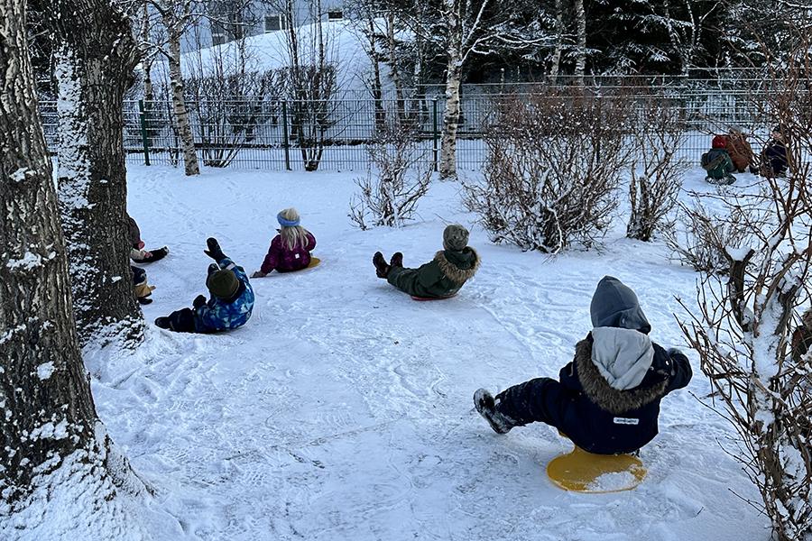 Krakkar á snjóþotum á lóð leikskólans Jörfa.