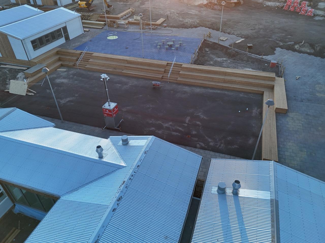 Myndir af lóð skólaþorpsins þar sem verið er að byggja palla og leggja hellur.