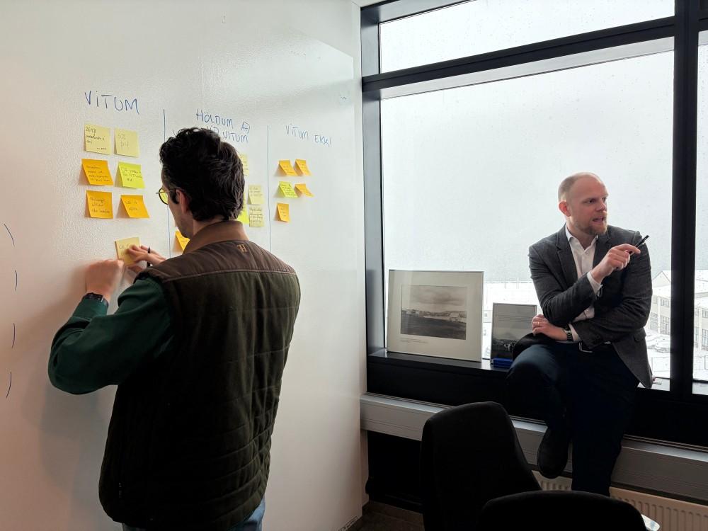 Post-it miðar með hugmyndum hengdir upp á vegg.