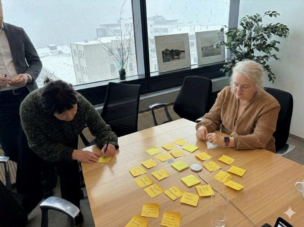 Þátttakendur í vinnustofu skrifa hugmyndir á Post-it miða.
