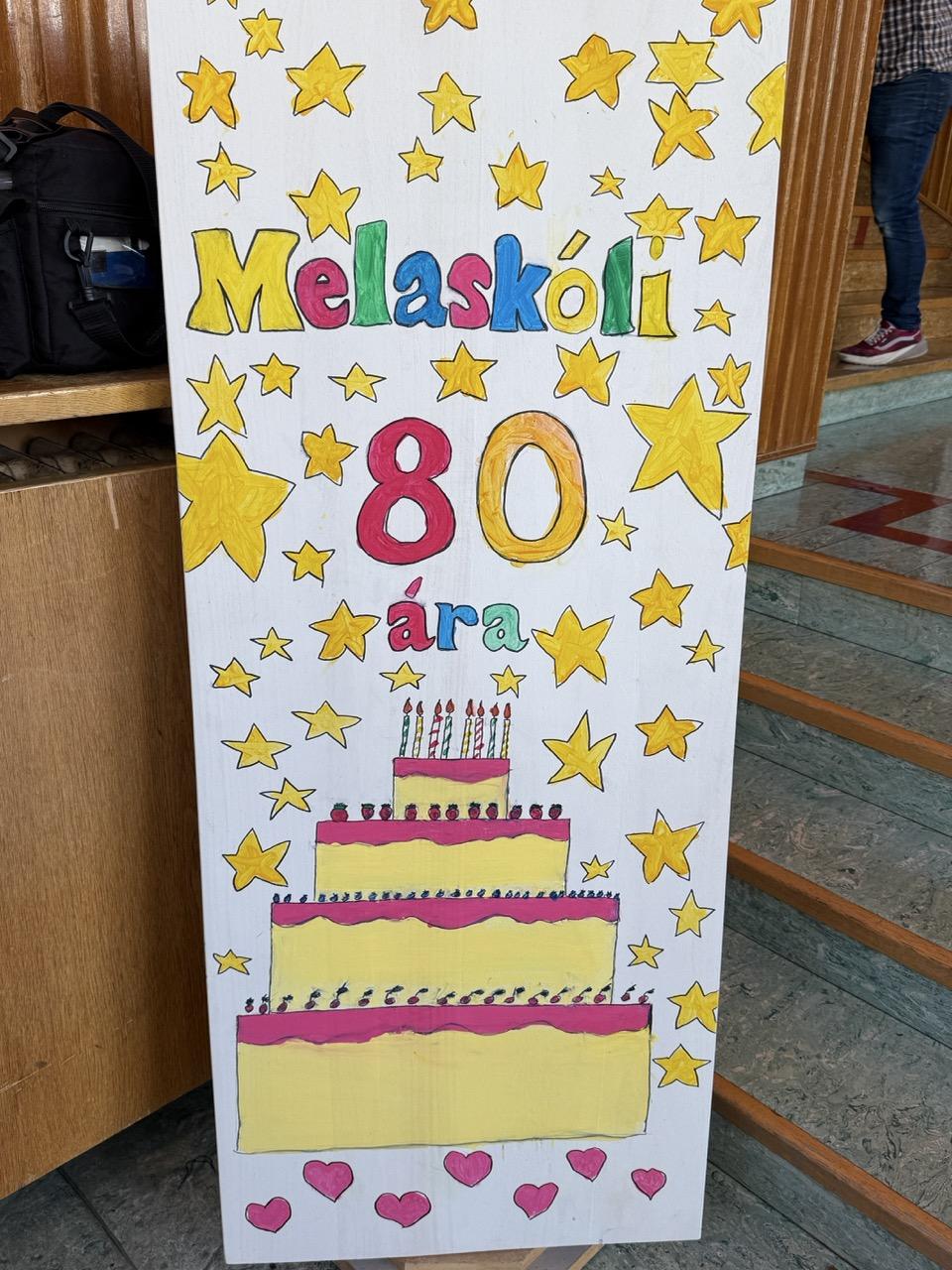 Veggspjald sem á stendur Melaskóli 80 ára.