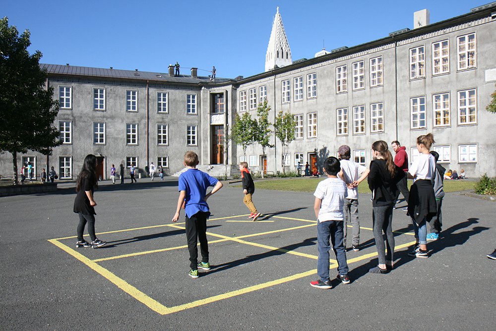 Children playing pogo on the grounds of Austurbæjarskóli.