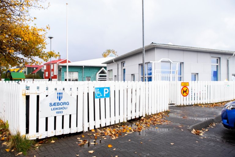 Ljósmynd af húsnæði leikskólans Sæborgar og hvítu grindverki.