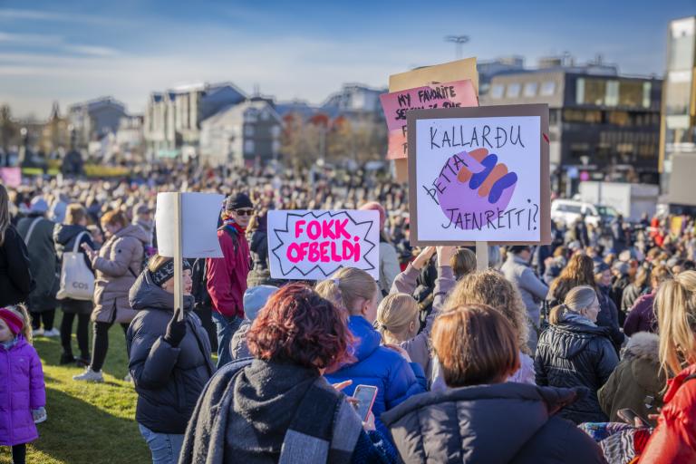 Mannhaf á Arnarhóli á kvennafrídegi 2023. Skilti með áletrunum fyrir miðju, FOKK OFBELDI OG KALLARÐU ÞETTA JAFNRÉTTI