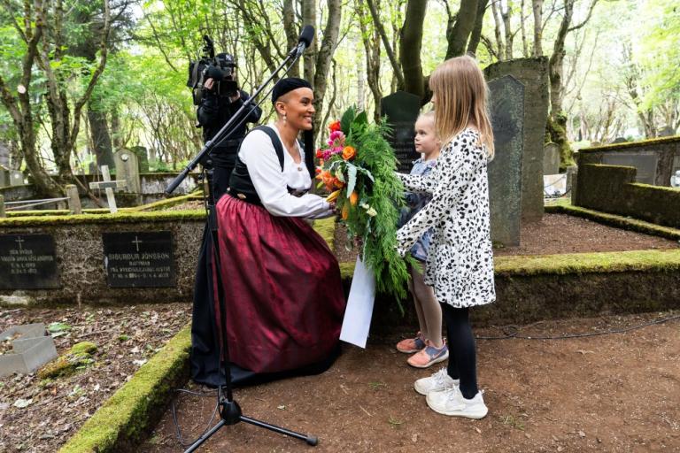 Sanna Magdalena Mörtudóttir, forseti borgarstjórnar, tekur við blómsveignum.