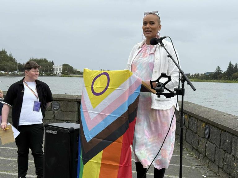Sanna Magdalena Mörtudóttir, President of the City Council, delivers a speech as Helga Haraldsdóttir, chair of Reykjavík Pride, looks on.