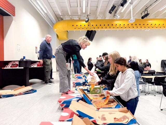 Meeting with young people featuring pizza and conversation.