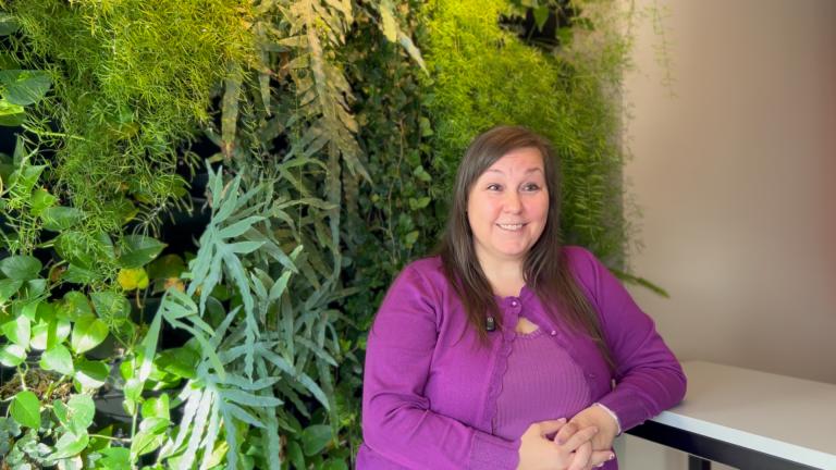 Elsa Katrín Pétursdóttir, at the financial management office of the Department of Finance & Risk Management. Portrait of her sitting by a living wall. Still from video.