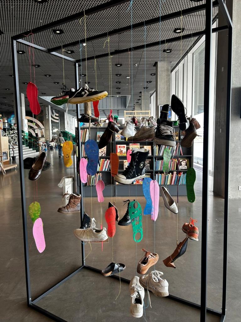 Shoes hanging at an art exhibit.