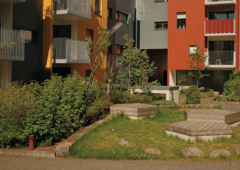 A lush garden next to a new building.