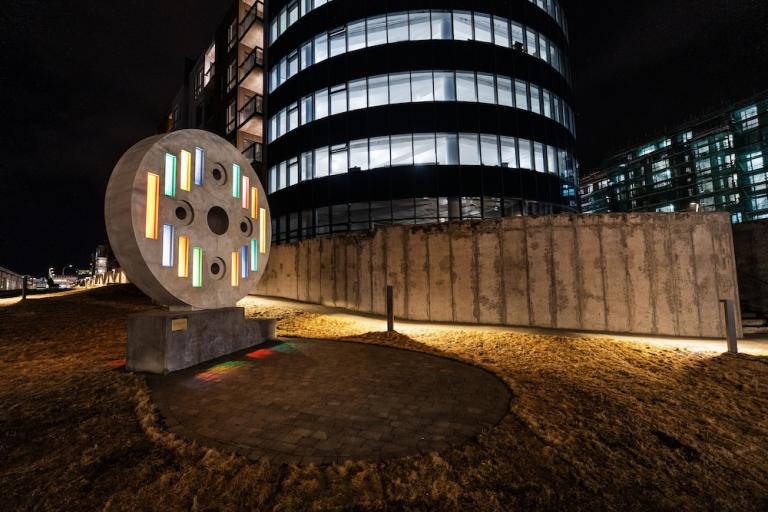 mynd af upplýstu listaverki og bogadregnum húsi