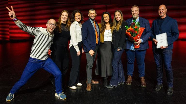 Fólk í röð með blóm og verðlaun.