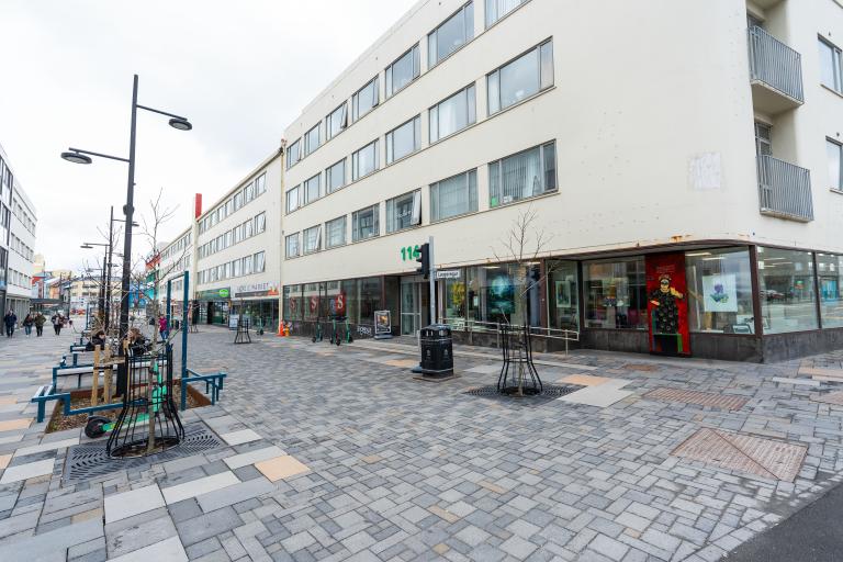 Hlemmur.Haus. Mynd tekin skáhallt að húsinu, hvítur himinn, stéttin fyrir utan í forgrunni.