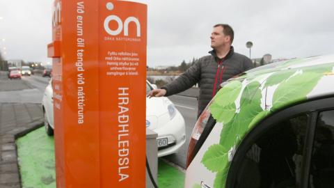 Maður hleður rafbíl