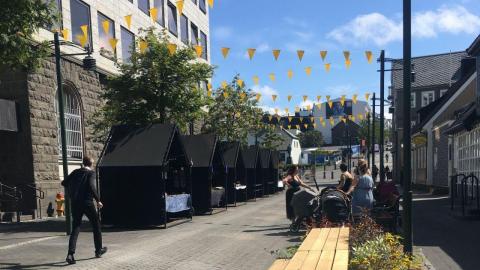 Sölubekkir, blóm og borð á sumardegi í Austurstræti.