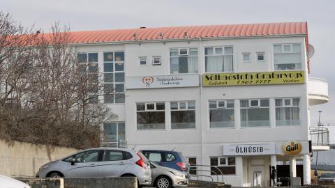 Hús Tónlistarskólans í Grafarvogi og bílar á bílastæði.