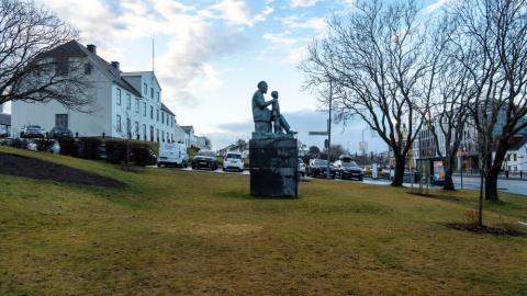 Minnismerki um séra Friðrik við Lækjargötu. Víð mynd, horft á hlið styttunnar úr nokkurri fjarlægð, í átt að MR.