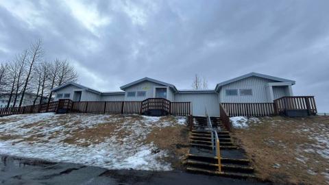 Hús Bakkasels frístundamiðstöðvar sem standa uppi á hæð. Tröppur upp að húsinu og gras til hliðar. 