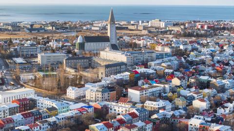 An aerial view of Reykjavík's city center shows Hallgrímskirkja church and the blue straits. 