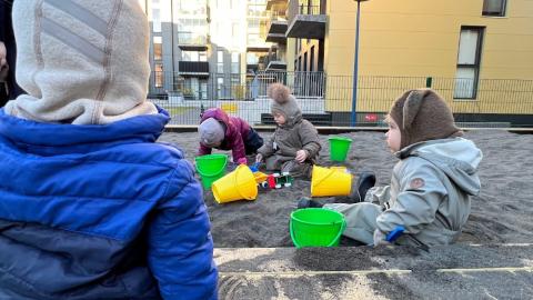 Börn að leika í sandkassa.