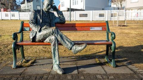Tómas Guðmundsson sits on the bench by Tjörnin pond on a beautiful day 