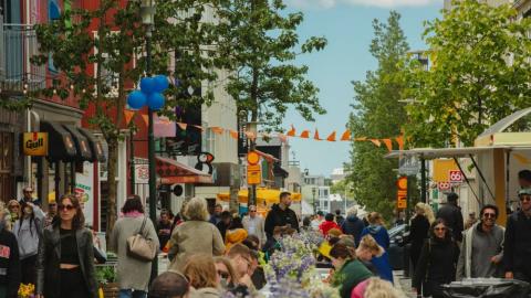 Crowd on Laugavegur street where a long table has been set up in the middle of the street