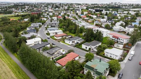 An aerial view of a Reykjavík neighborhood in summer, with trees in the foreground.
