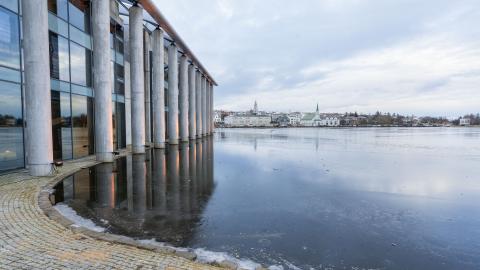 Ráðhúsið, sjónarhorn frá Tjarnargötu. Fyrir miðju má sjá Fríkirkjuna og Hallgrímskirkju, Tjörnin í forgrunni, Ráðhúsið til vinstri. Logn.