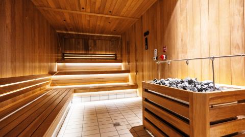 New sauna at Vesturbæjarlaug. Wood, no people, stones in foreground.