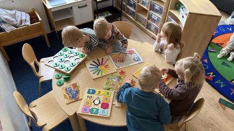 Mynd af leikskólabörnum skoða bækur.