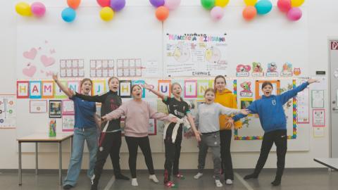 Stúkur í Engjaskóla fyrir framan hamingjuvegg í skólanum.