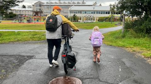 A father and daughter on their way to school.