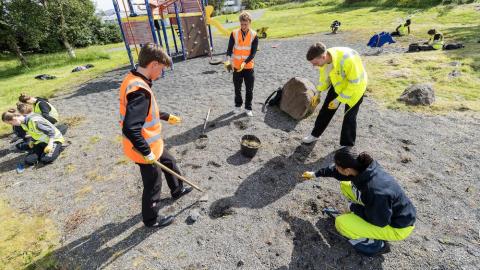 Krakkar að raka og vinna við hreinsun.