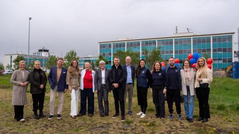 Development partners stand on the building site in front of Hotel Natura.